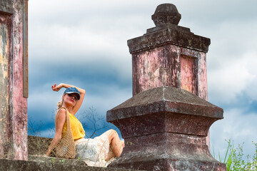 A woman sits on ancient ruins in Nha Trang, Vietnam - a moment of silence amidst the historical...