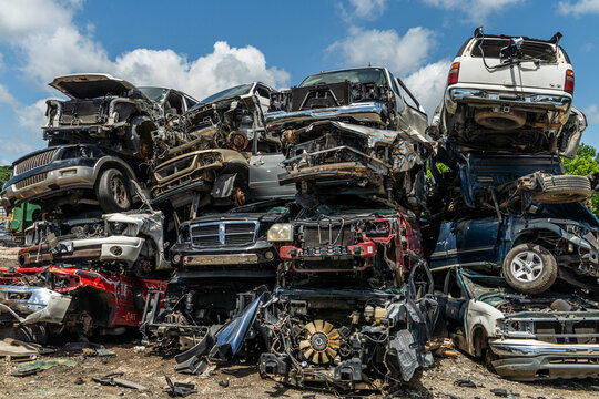 A pile of wrecked cars in a scrap yard
