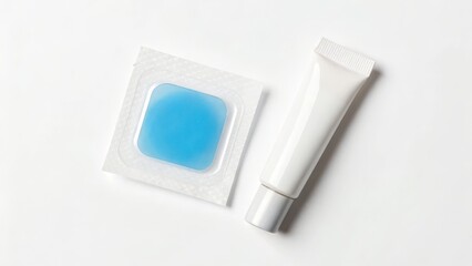 A white cosmetic tube and a blue hydrogel eye patch on a white surface, suggesting skincare or beauty treatment products.