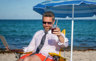 Travel and business. Man freelance work online at sea beach. Businessman working at sea summer vacation. Online freelance. Businessman remote worker with laptop. Business man using laptop in beach