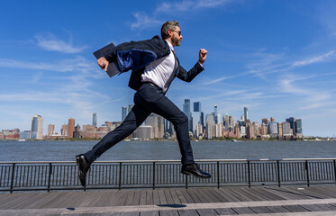 Successful businessman hurrying on New York city skyline. Business man in Manhattan. Business success in big city. Businessman running to success. Business success. Late meeting