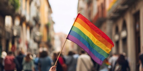 The rainbow flag waving proudly in a vibrant urban street celebration.