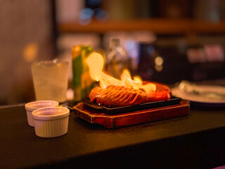 Sausage on a sizzling hot plate with flames in a high end restaurant in old Phuket town Thailand...