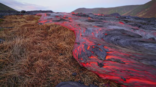 Lava flow over dry grass dramatic volcanic landscape photography