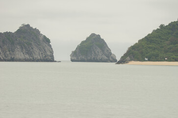 Limestone cliffs and sandy beach. Lan Ha Bay. Cat Ba Archipelago. Vietnam.