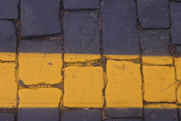 road markings on road paving stones, yellow paint on dark paving stones, 2