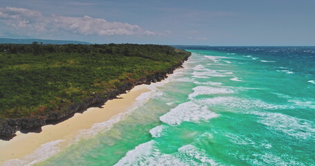 Breathtaking aerial view capturing turquoise ocean waves crashing onto an idyllic white sand beach,...