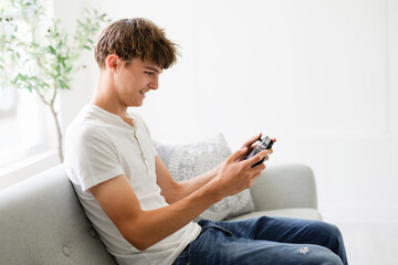 european teen play handheld console on sofa