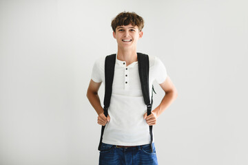 Portrait of teenage student boy in casual t-shirt on light background in studio.