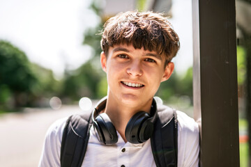 Portrait of smiling elementary school boy with his backpack waiting the bus