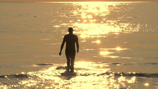 silhouette of a man walking on the beach