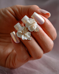 Luxurious white pearlescent manicure with floral embellishments and gems