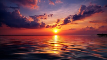 Fototapeta premium Vibrant Sunset Over Calm Ocean Waters with Dramatic Cloud Reflections in a Beautiful Landscape Scene