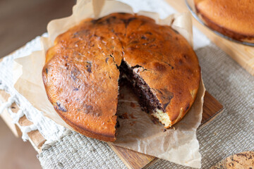 Delicious homemade marbled cake displayed on parchment paper. The swirled chocolate pattern adds a...