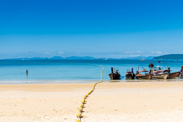 beautiful reflection of natural mountain and Longtail boat on send beach Railay Beach, in Krabi, Ao Nang, Thailand. -summer day