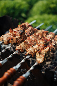Close-up of juicy grilled skewers on a charcoal barbecue