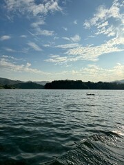 Big white clouds, blue sky, water and mountains