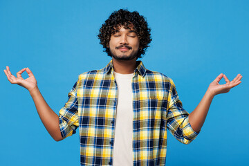 Young happy Indian man he wear yellow checkered shirt casual clothes hold spread hands in yoga om...