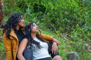 Two young women relaxing together in nature, embracing friendship and serenity