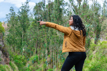 Female tourist pointing at something in lush green forest