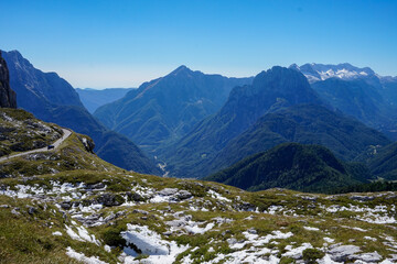 Breathtaking Panoramic View of Majestic Mountains and Winding Road in Triglav National Park, Julian Alps, Slovenia on a Clear Sunny Day