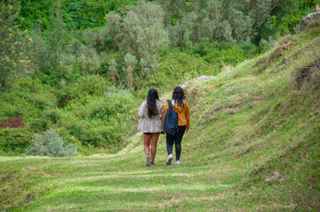 Two tourists walking in green landscape exploring nature