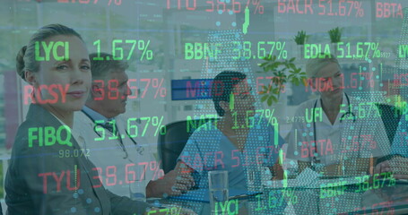 Discussing hospital staff reviewing data on table in meeting room at hospital, with ticker overlay