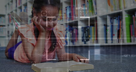 Reading girl lying on carpeted library floor, focusing on open book with digital overlay