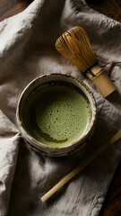 Matcha green tea bowl with whisk and linen cloth still life photography for healthy drink and wellness concept