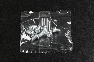 Fasteners. Eight silver screws in a package