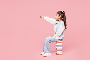 Full body side view young school girl 8-9 years old wear blue casual clothes sit stack of books...