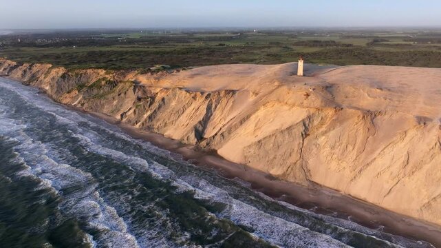 Aerial view of the giant sand dunes with the famous lighthouse on the top of a hill. Rubjerg Knude Lighthouse, , North SeaRubjerg , Sunset at the lighthouse Rubjerg Knude Fyr near Lokken in Denmark. 