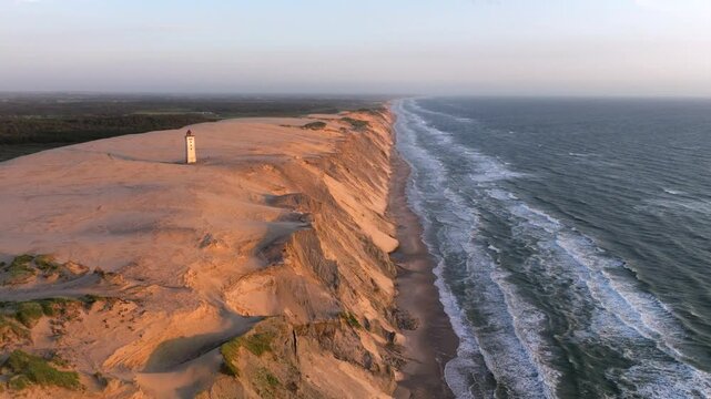 Aerial view of the giant sand dunes with the famous lighthouse on the top of a hill. Rubjerg Knude Lighthouse, , North SeaRubjerg , Sunset at the lighthouse Rubjerg Knude Fyr near Lokken in Denmark. 