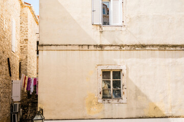 Weathered facade with laundry in the alley. Urban texture, daily life, and Mediterranean...