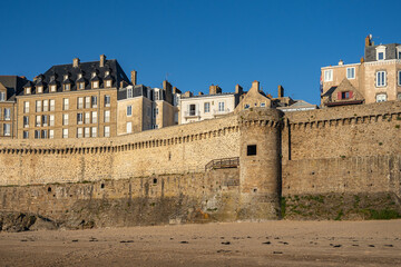 Stone fortifications and Notre-Dame tower on the Saint-Malo city wall, viewed from the beach at low tide, Brittany, France