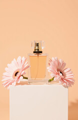 Glass perfume bottle with peach liquid and pink flowers
