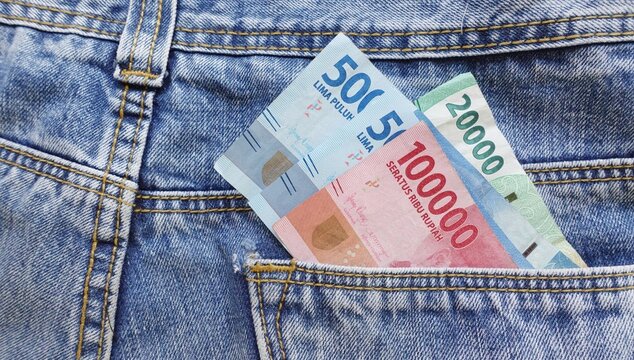 Rupiah banknotes come out of jeans pocket. Consumptive concept.