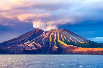 Fototapeta premium Dramatic sunset over a volcanic landscape with smoke plume