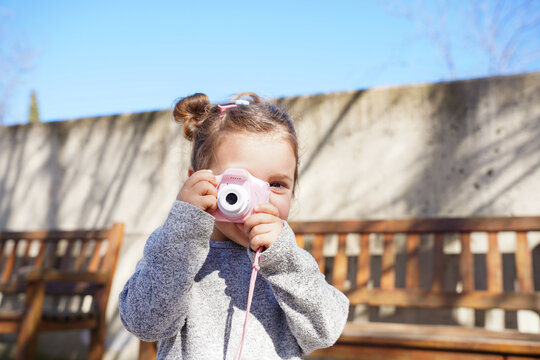 Little girl capturing moments with toy camera in park