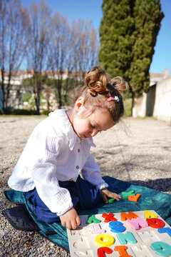 Little girl enjoying a day in the park with a puzzle