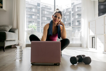 Woman training with laptop at home in living room