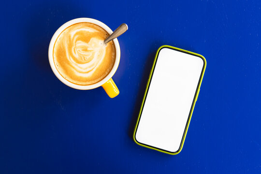 Coffee and smartphone on blue table