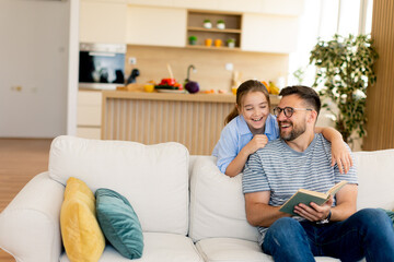 Joyful moments of laughter and storytelling between a father and daughter in a cozy living room