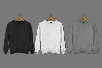 A grey, black and white sweaters mockup are hanging on the wall.3d rendering.
