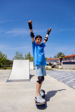 Teen boy skateboarding joyfully under blue sky