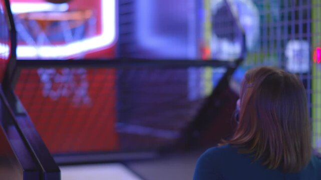 Girl playing basketball arcade game
