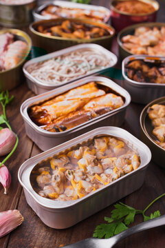 Variety of canned seafood displayed on wooden table