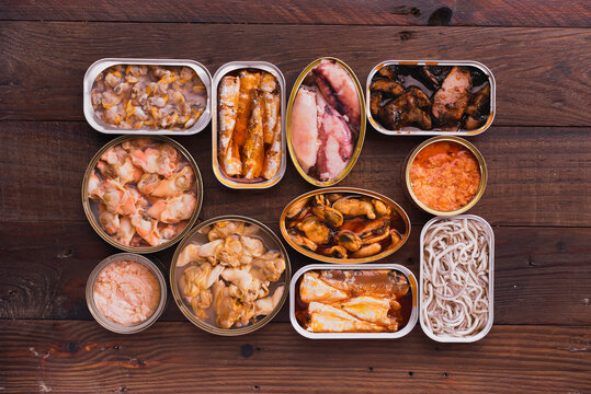 Assorted canned seafood presented from above on wood