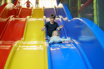 Children enjoy vibrant slides in a play area during a sunny afternoon, creating joyful memories and laughter
