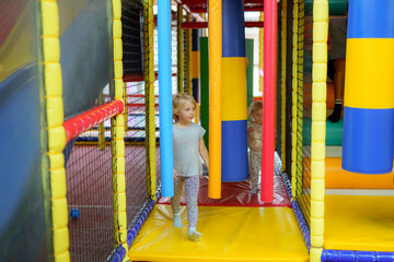 Children enjoying an indoor play area filled with colorful structures and climbing frames in a recreational center